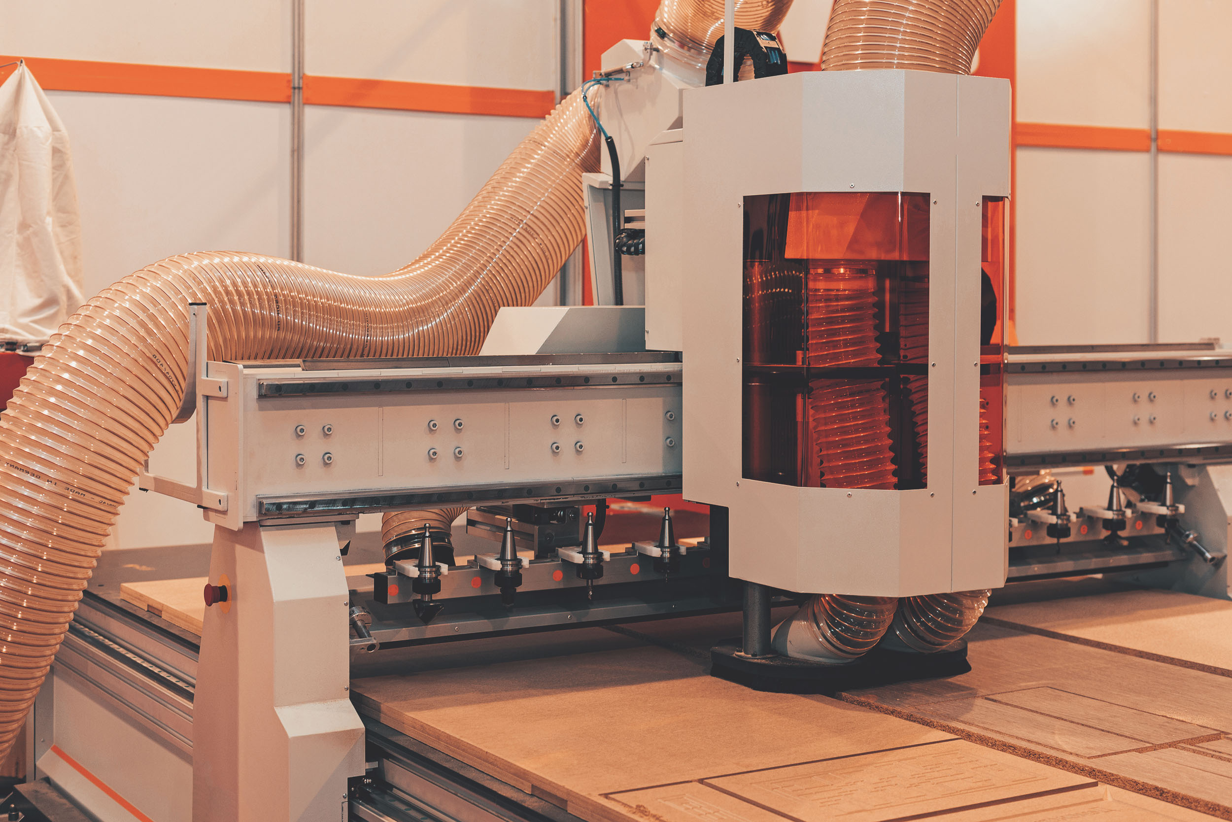 Industrielle Holzbearbeitungsmaschine mit Absaugschläuchen in einer Werkhalle