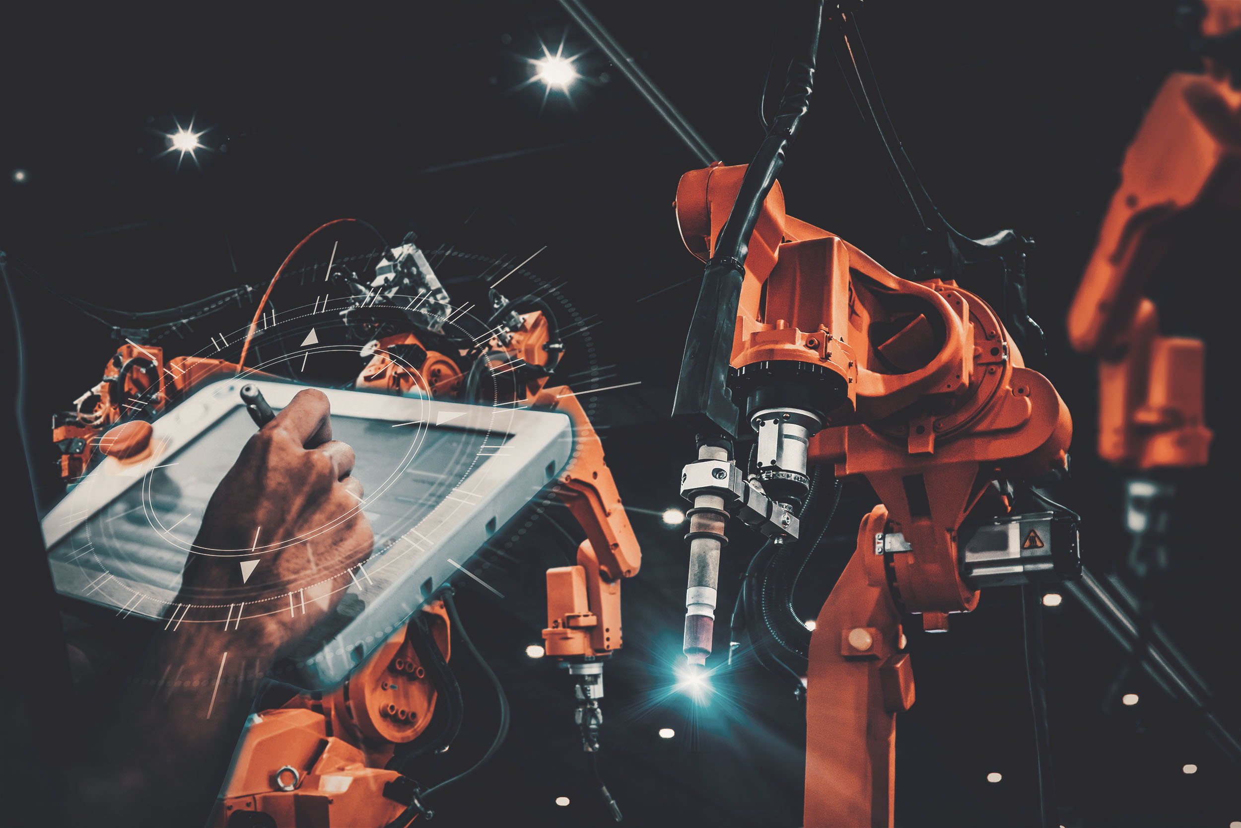 Person operating a tablet to control robotic arms