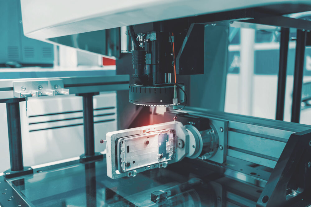 Industrieroboter mit Laserbearbeitung an einem elektronischen Bauteil in einer Fertigungsanlage