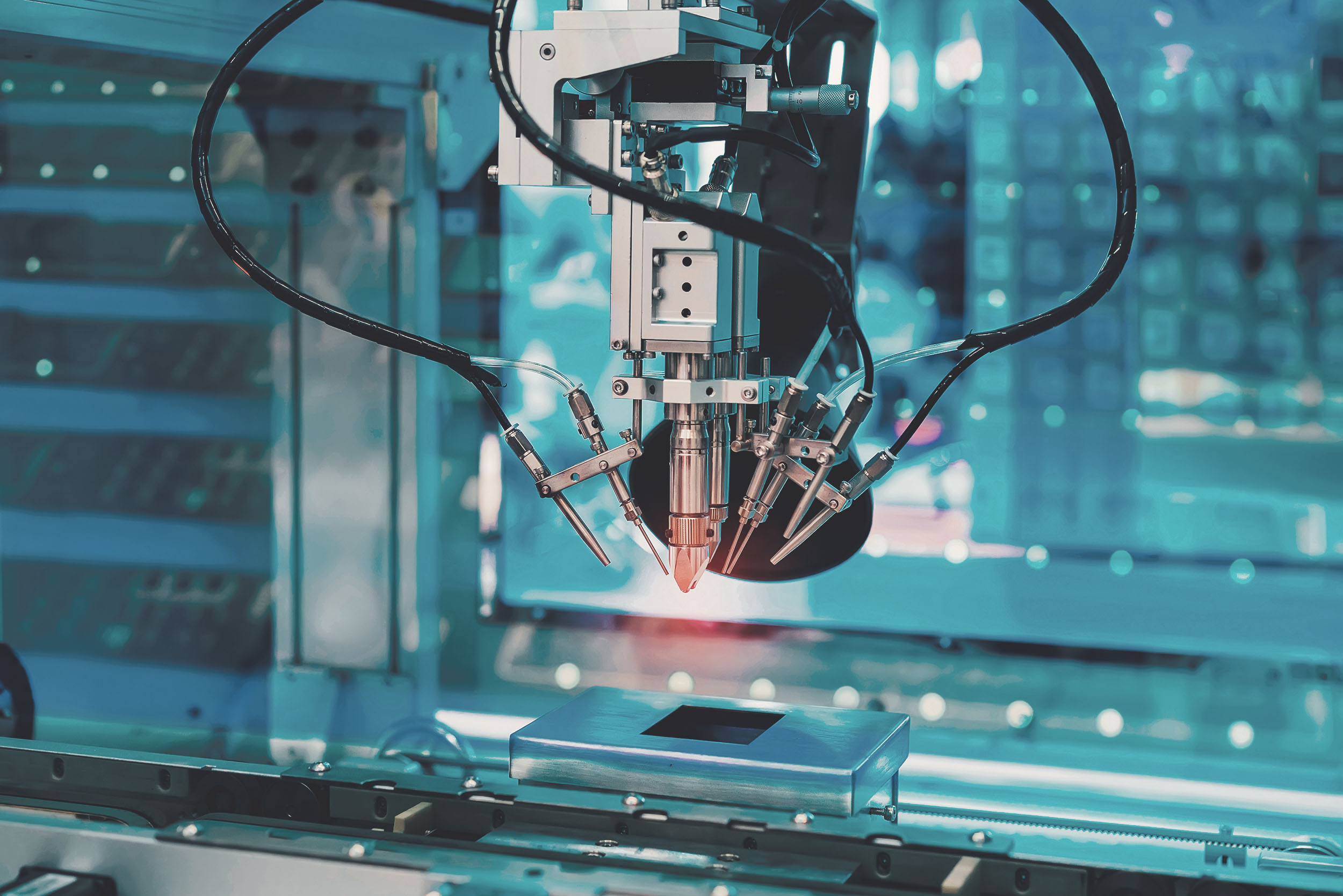 Industrieroboter mit mehreren Greifarmen über einer Förderstrecke in einer Elektronikfertigung
