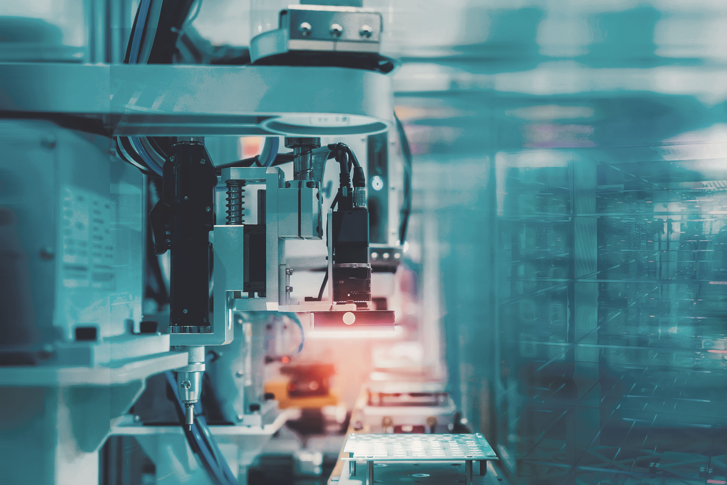 Industrieroboter mit Greifarm in einer automatisierten Fertigungsanlage mit Halbleiter- oder Elektronikkomponenten