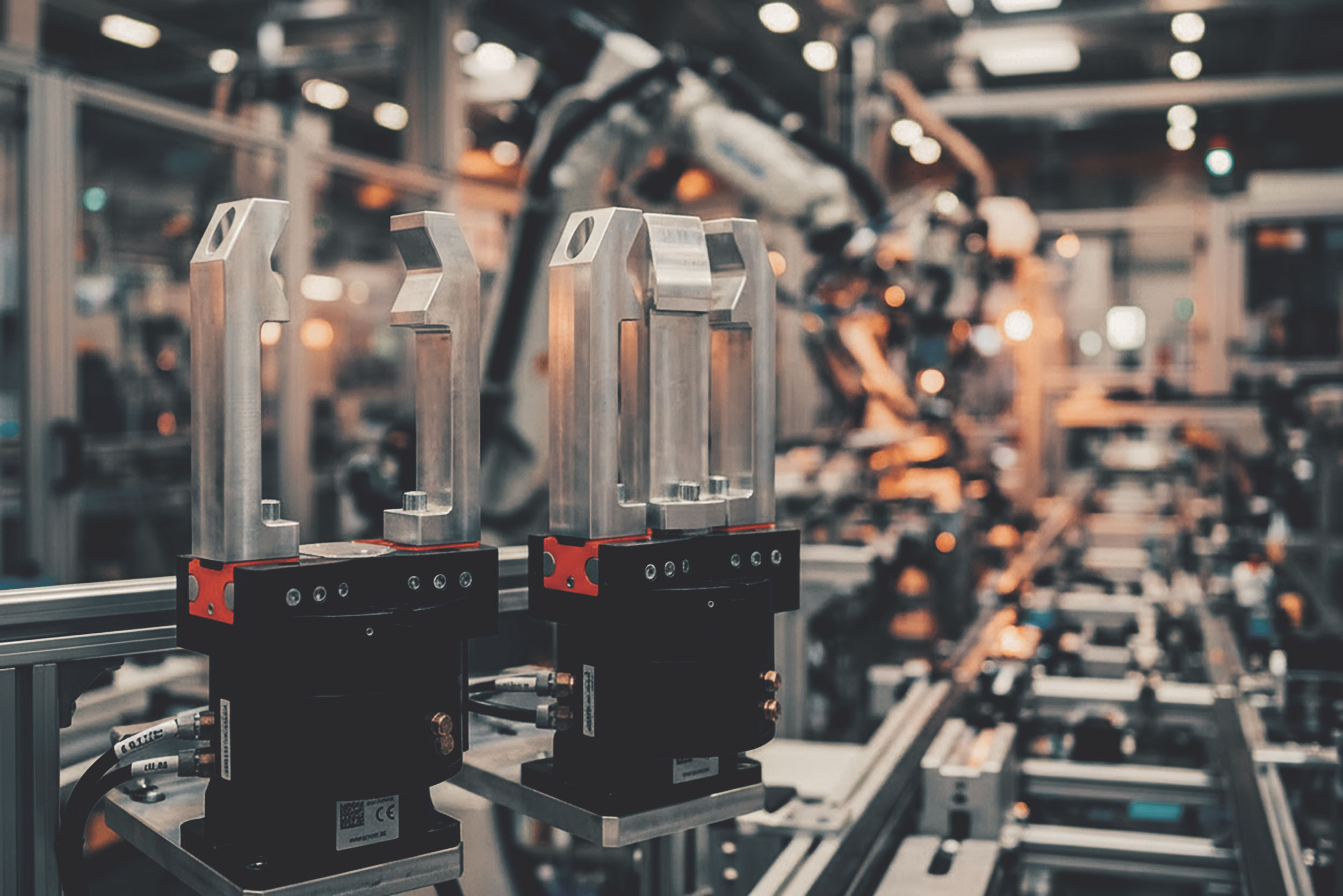 Zwei mechatronische Module mit Metallarmen in einer industriellen Fertigungsanlage